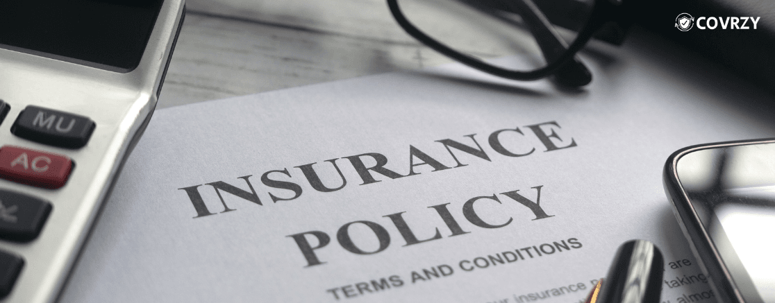 a paper with the name Insurance policy written on top, with a calculator and a spectacle visible partially