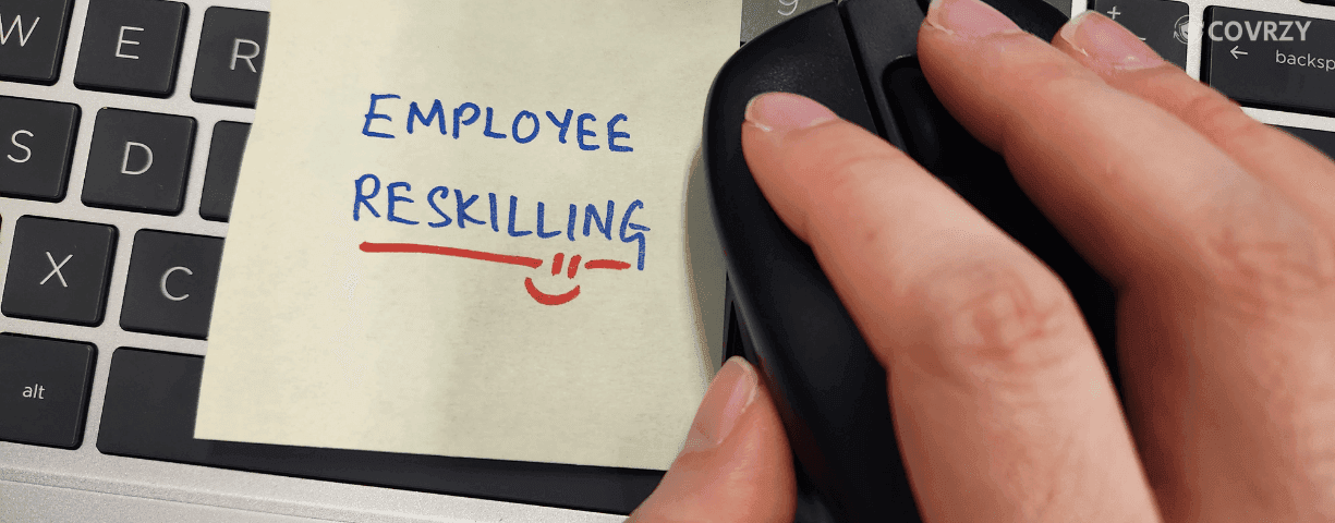 a hand placed on computer mouse with employee reskilling written under it