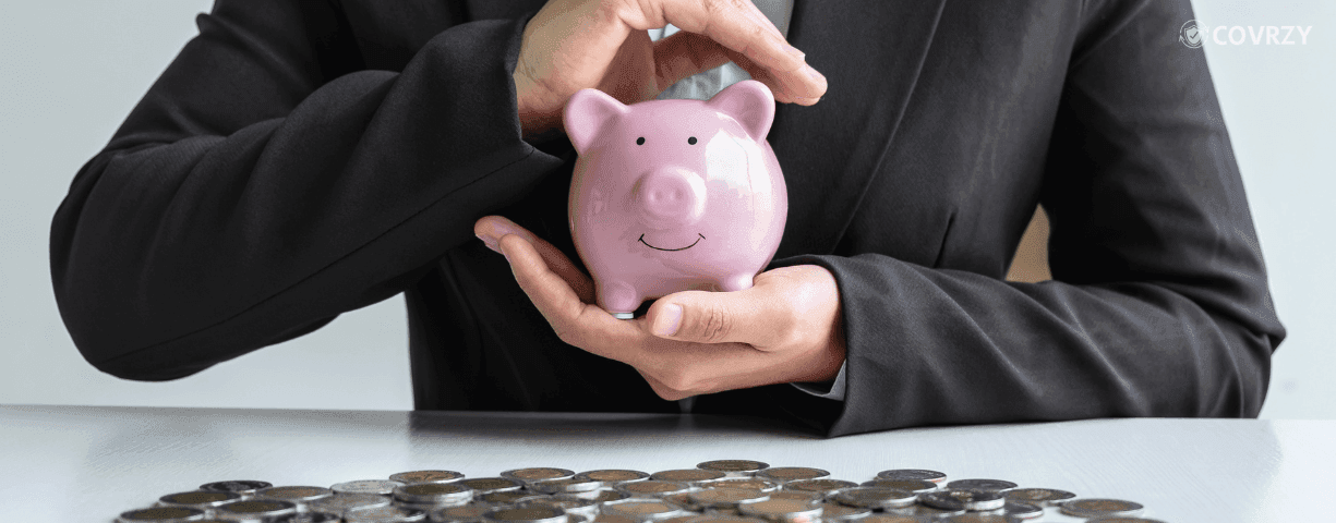 A person holding gratuity money in a piggy bank