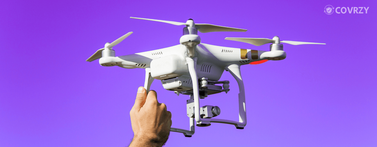A hand holding a drone in a violet background