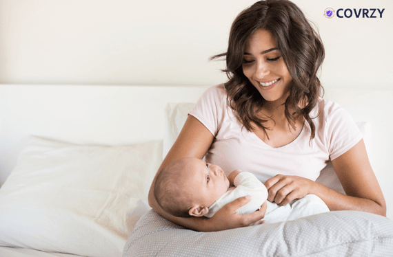 A mother is holding her newborn under maternity leave policy in India